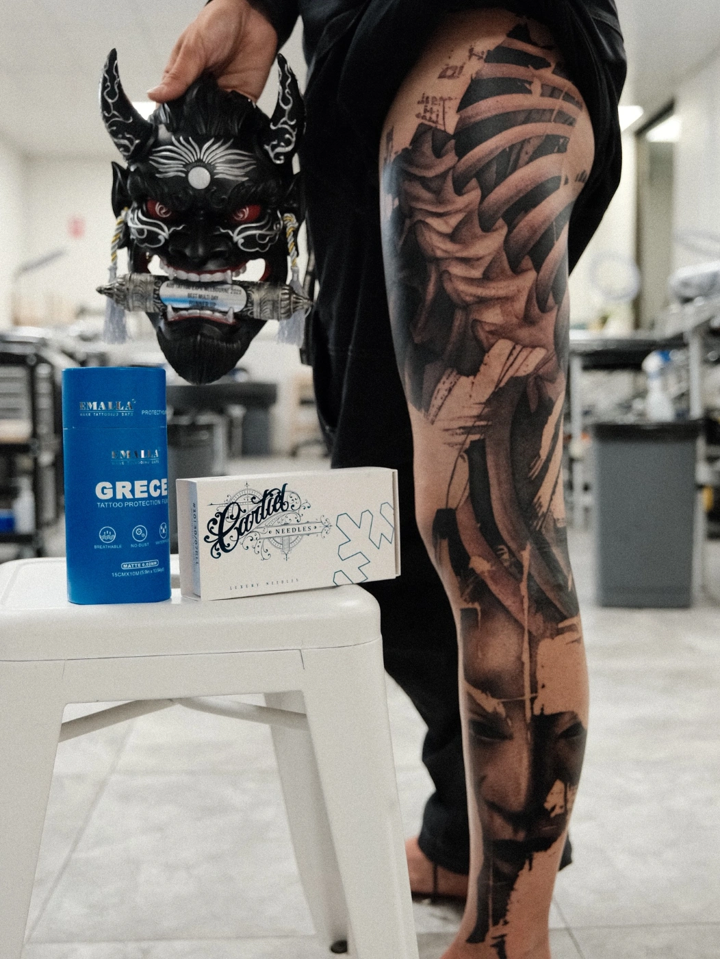 Detailed black-and-grey skull and skeleton tattoo on leg.