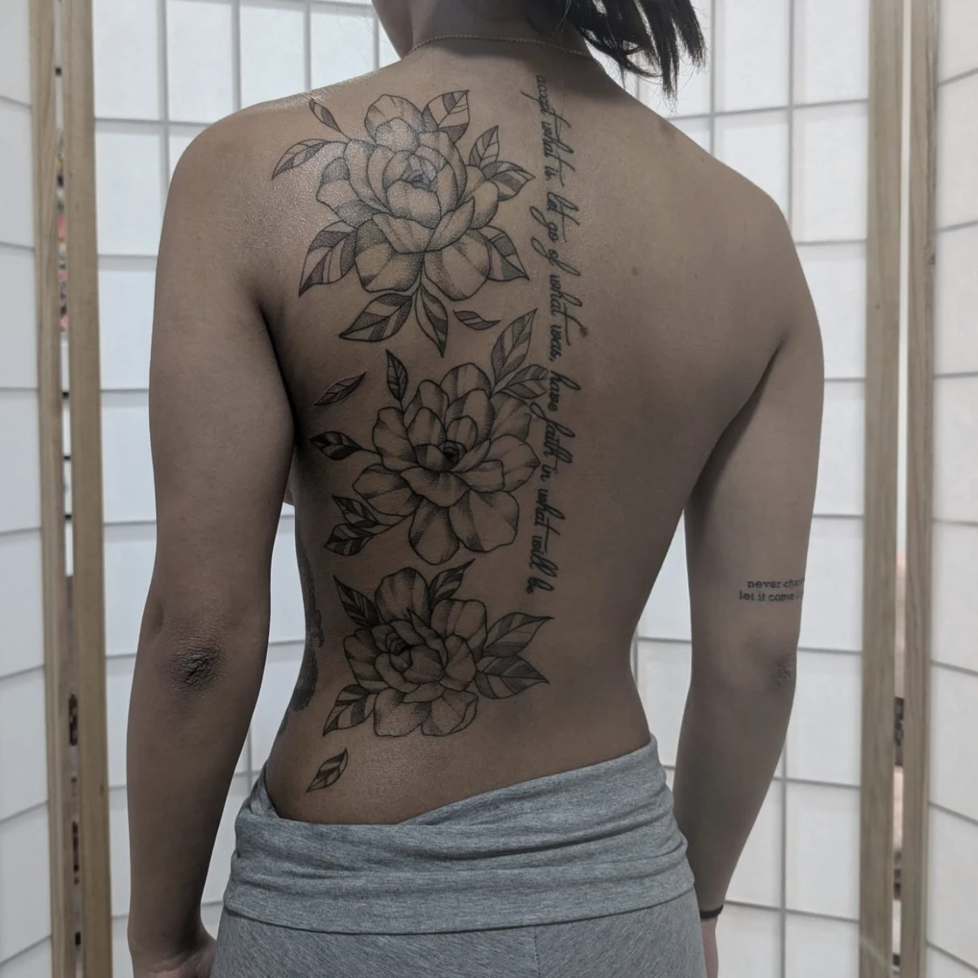 Large black-and-grey rose tattoo on the back.