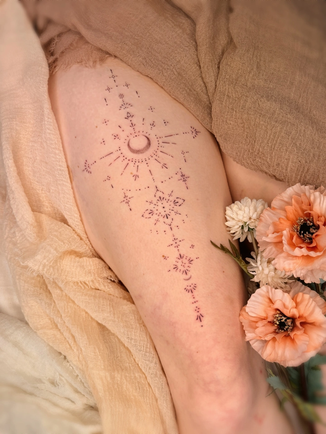 Minimalist sun and stars tattoo on thigh.