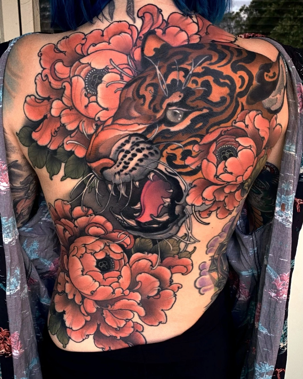 Large back tattoo of a tiger surrounded by peonies.