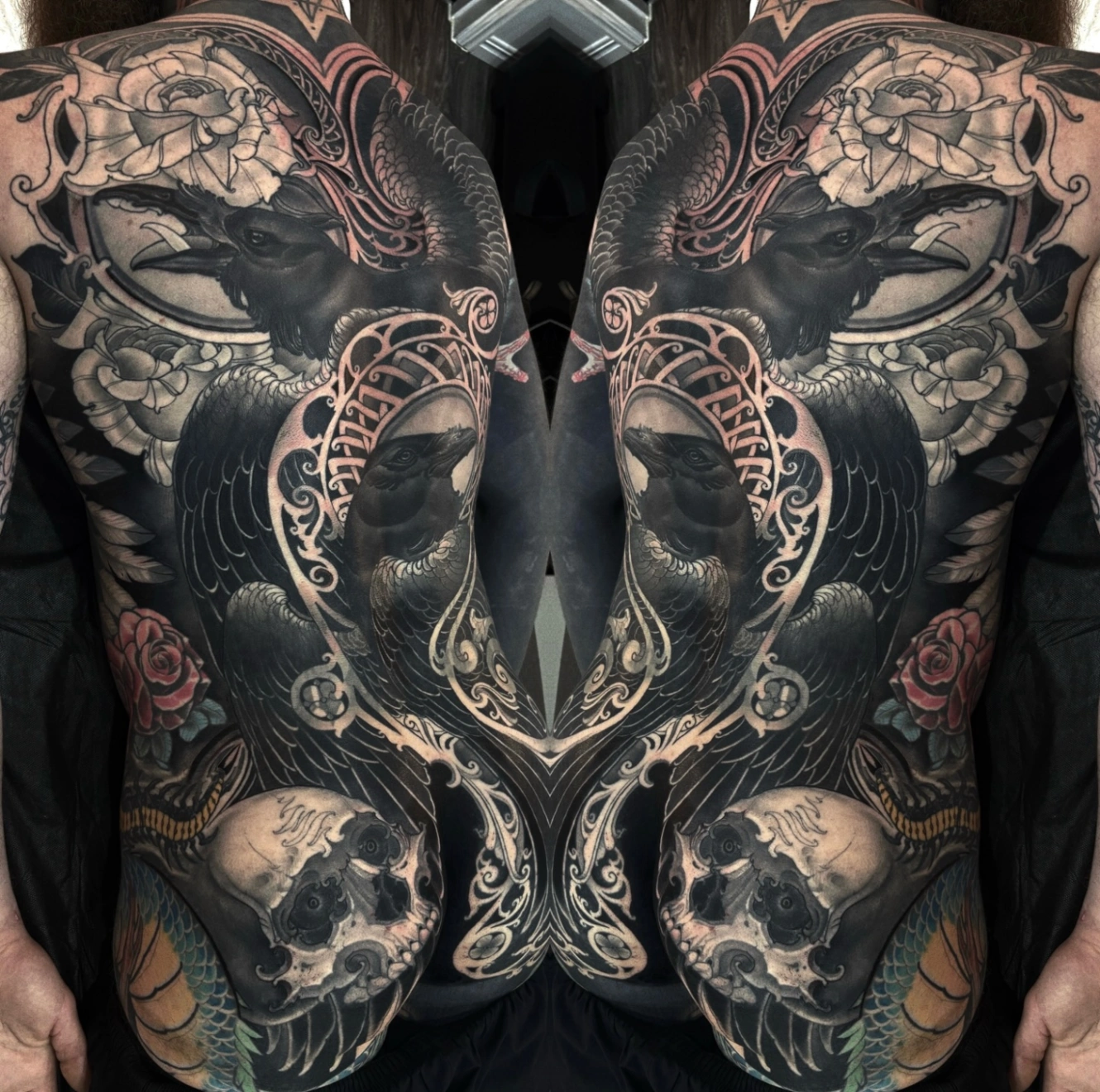 Black-and-grey illustrative back tattoo of raven and roses