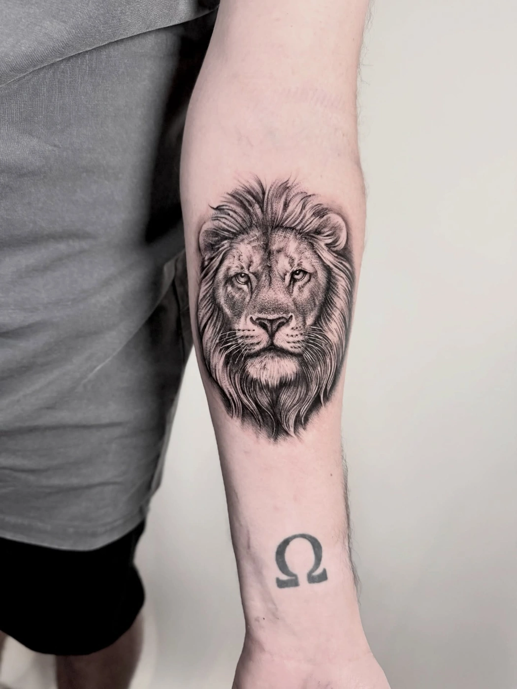 Black-and-grey realism lion tattoo on forearm