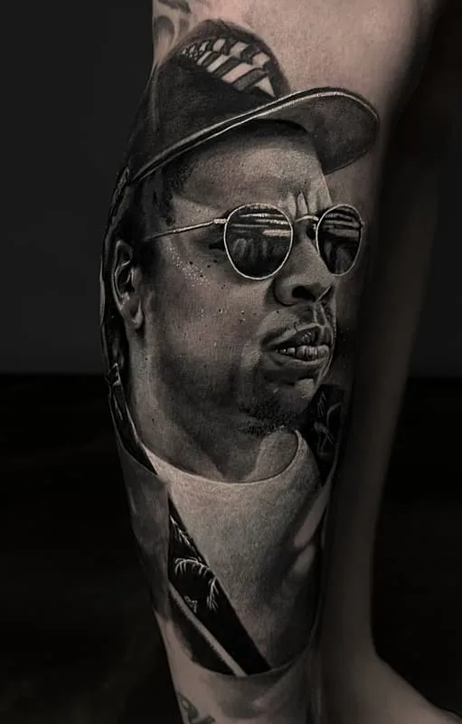 Realistic black-and-grey portrait tattoo on leg.