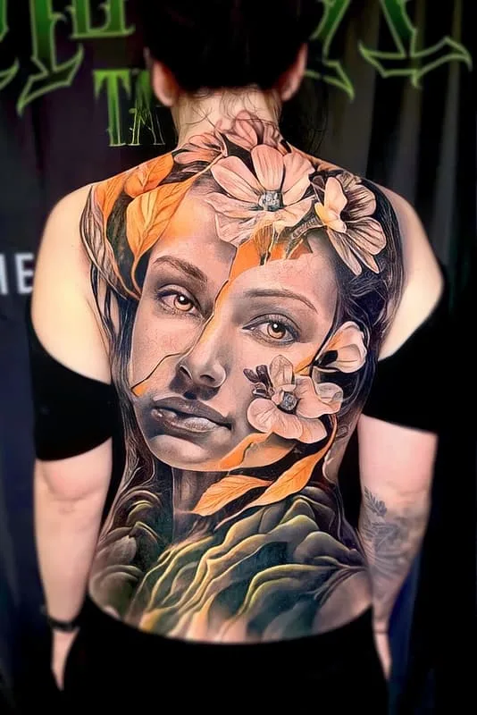 Realistic portrait tattoo with flowers on a woman's back.