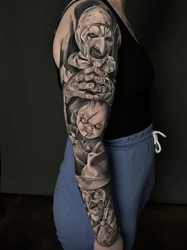 Large horror-themed full-sleeve tattoo in black and grey.