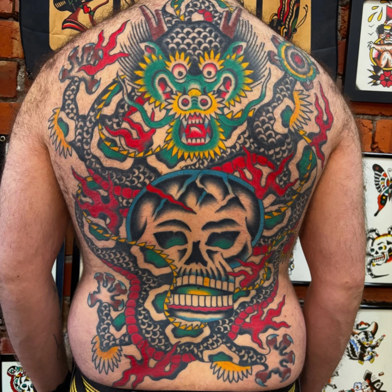 Large traditional tattoo of a dragon and skull on the back.