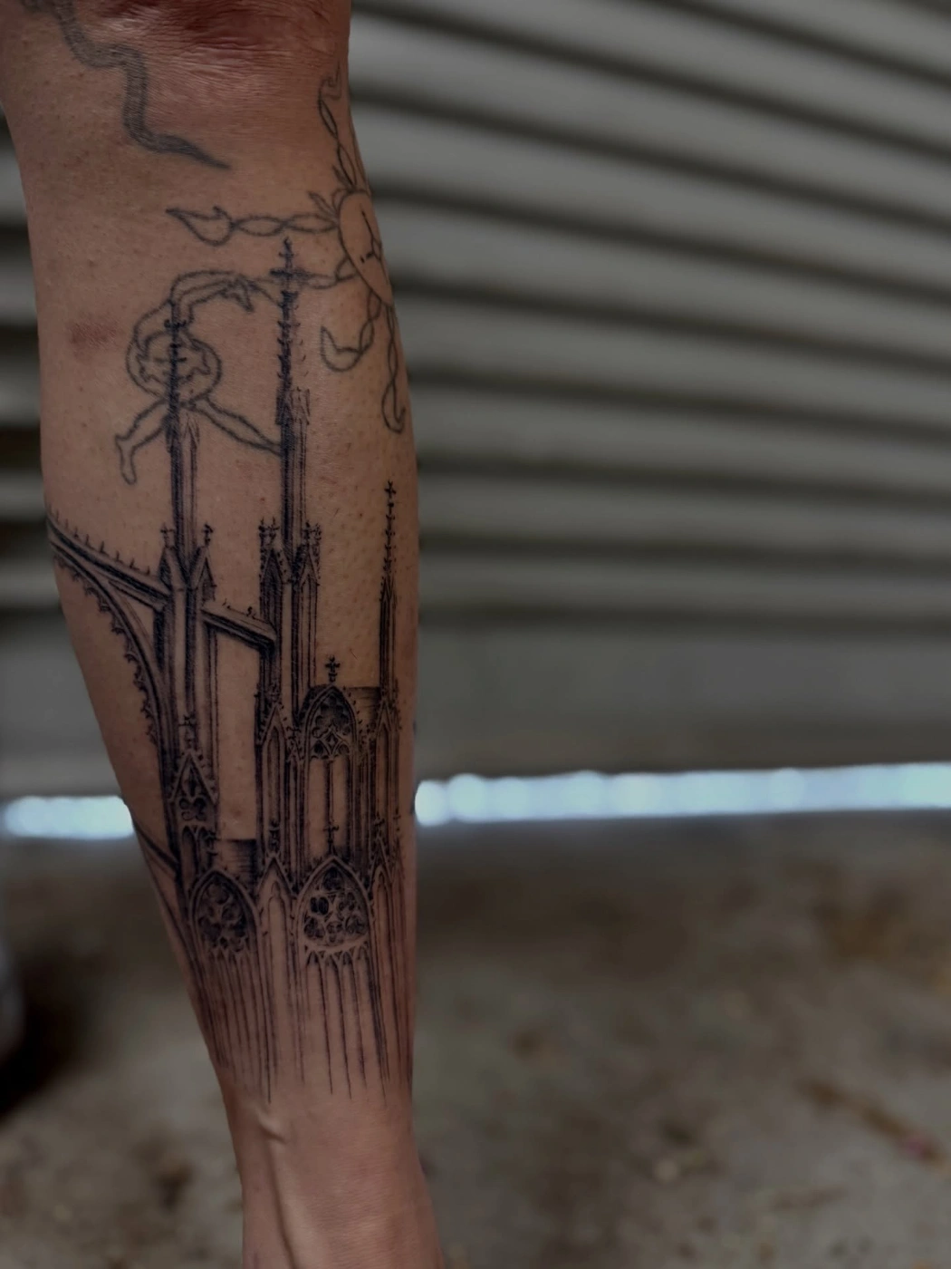 Intricate cathedral tattoo design on calf.