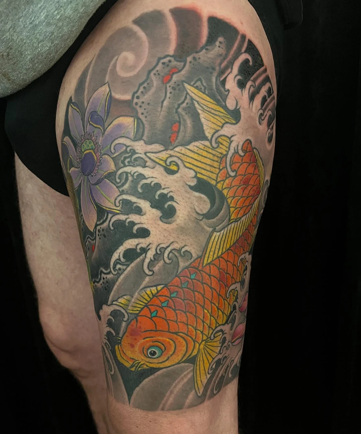 Japanese koi fish tattoo with lotus flower on thigh.