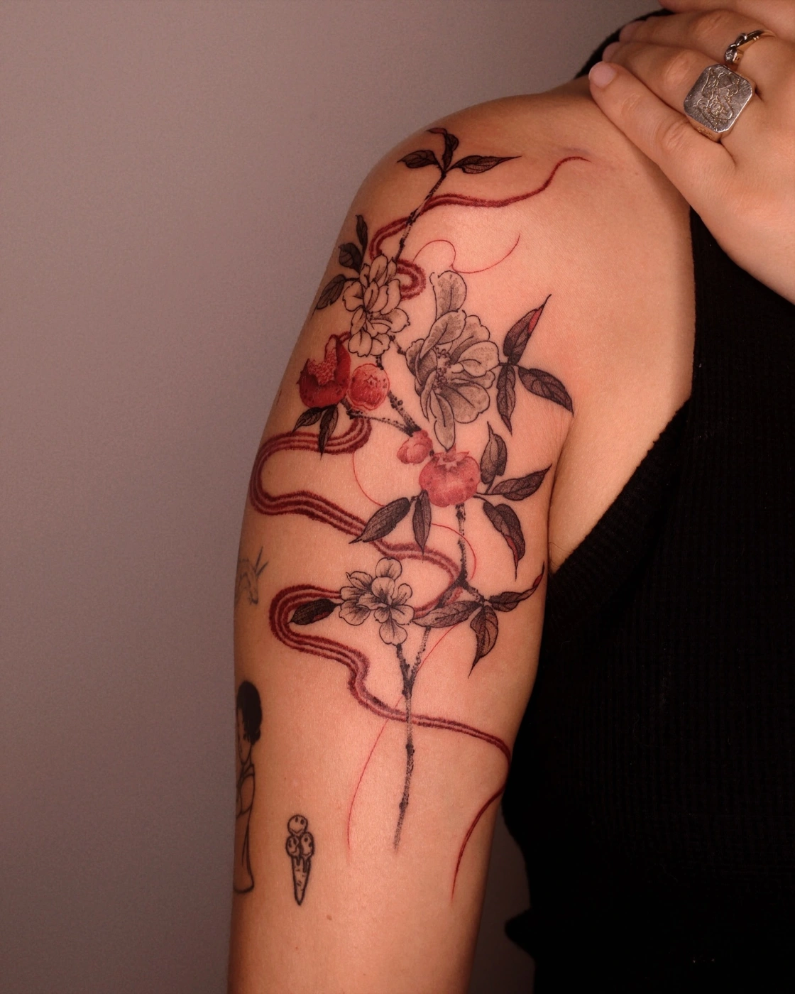 Colorful watercolor flower tattoo on shoulder and arm.