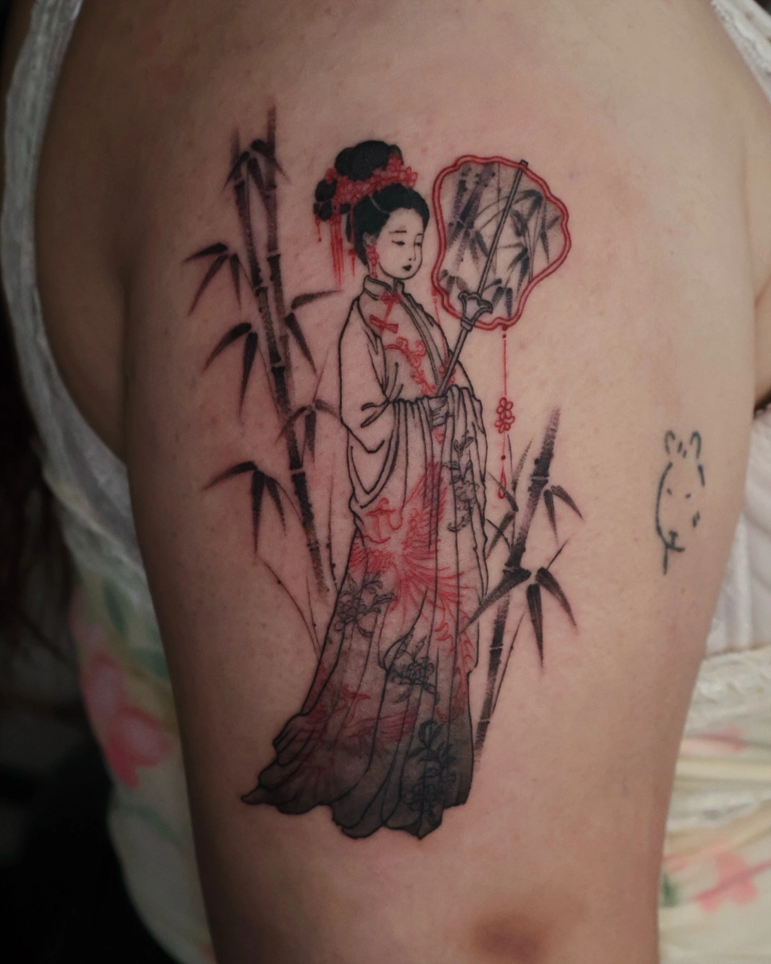 Illustrative geisha tattoo with bamboo on arm.