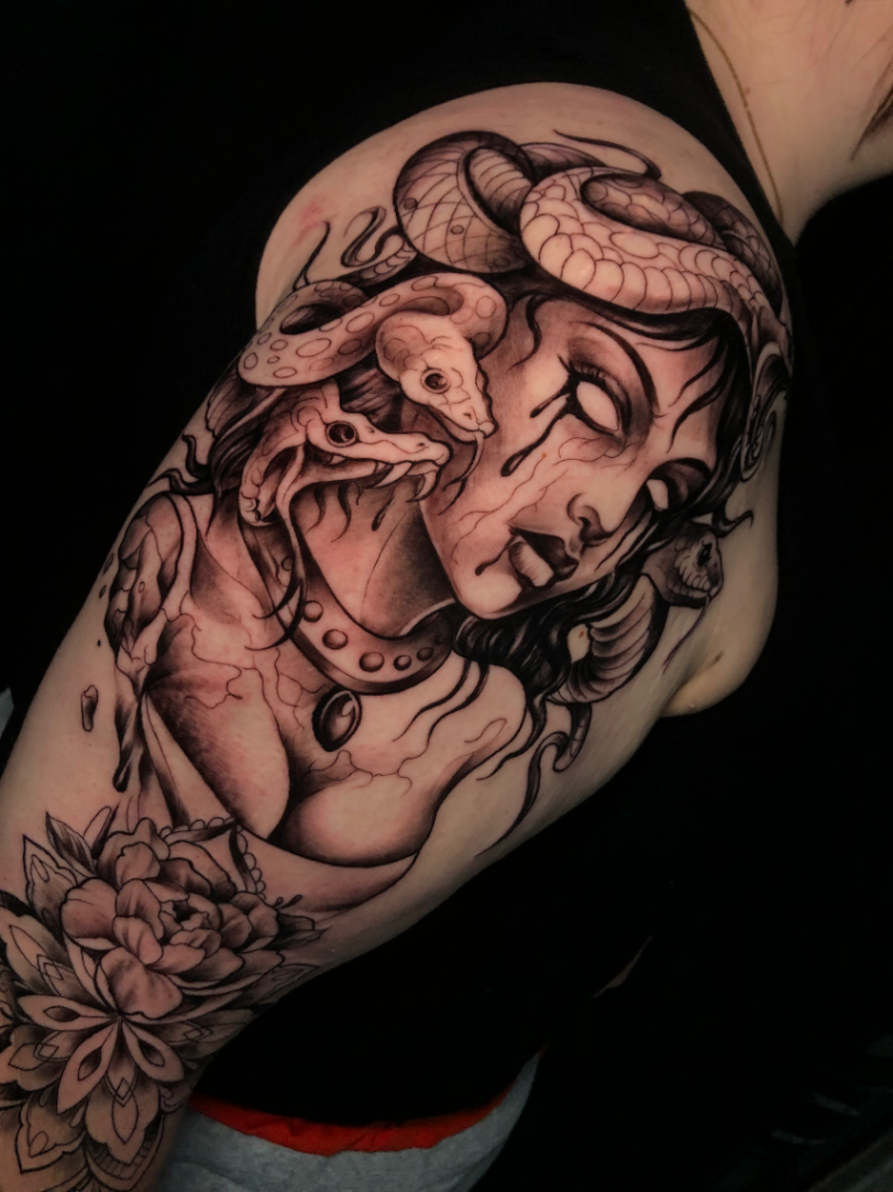 Detailed black-and-grey tattoo of a woman with snake and octopus.