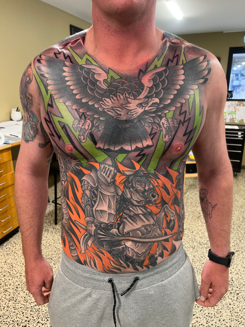 Large colorful chest tattoo featuring an eagle and knight.