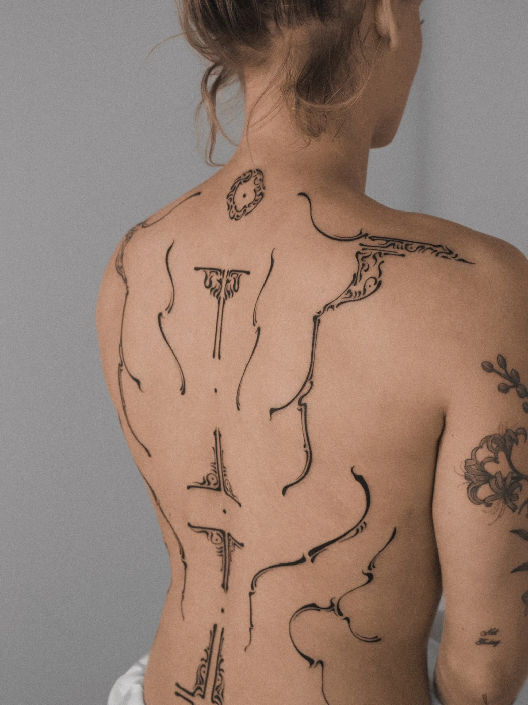 Intricate blackwork geometric tattoo on a woman's back.