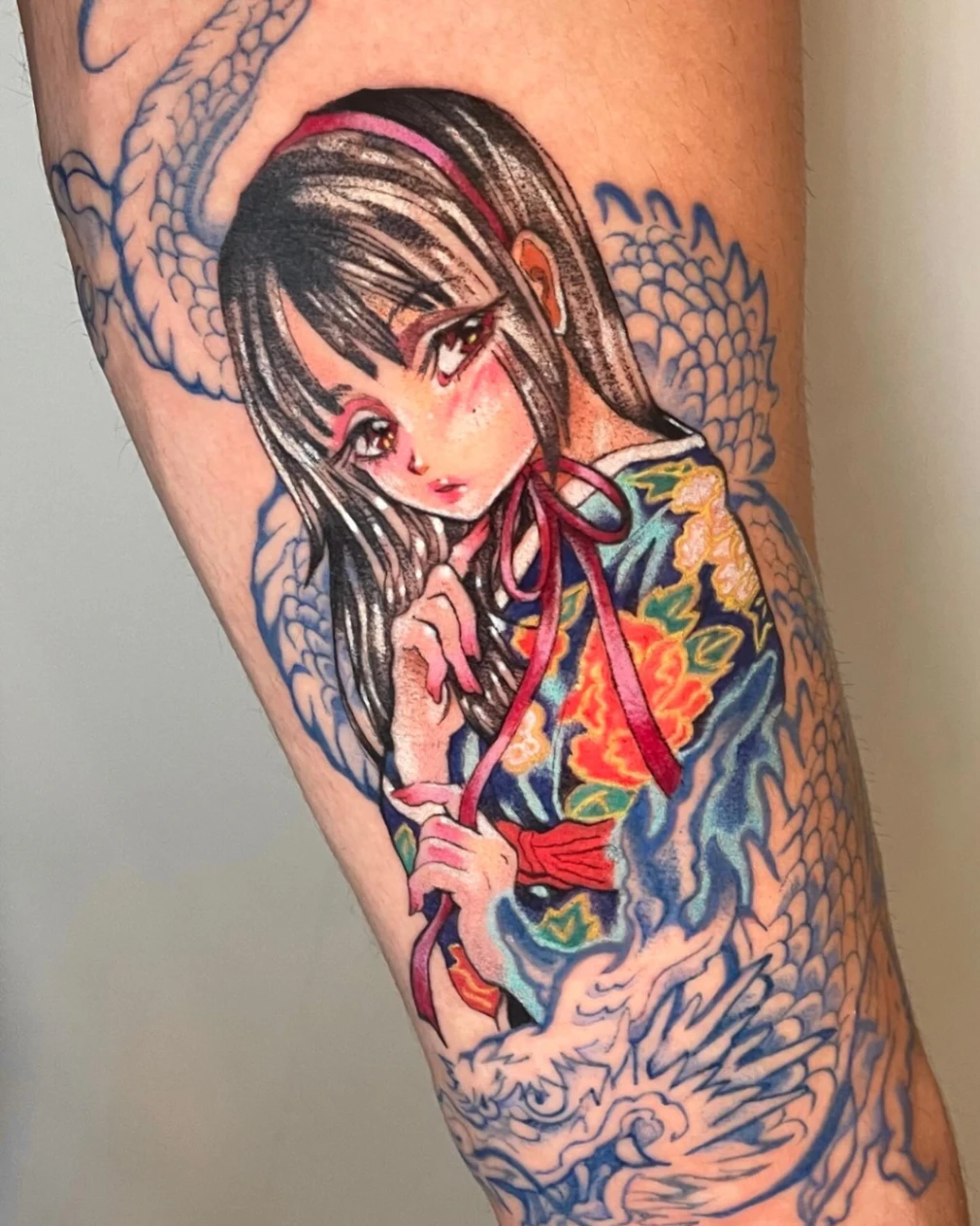 Illustrative tattoo of a girl in a kimono with a dragon.