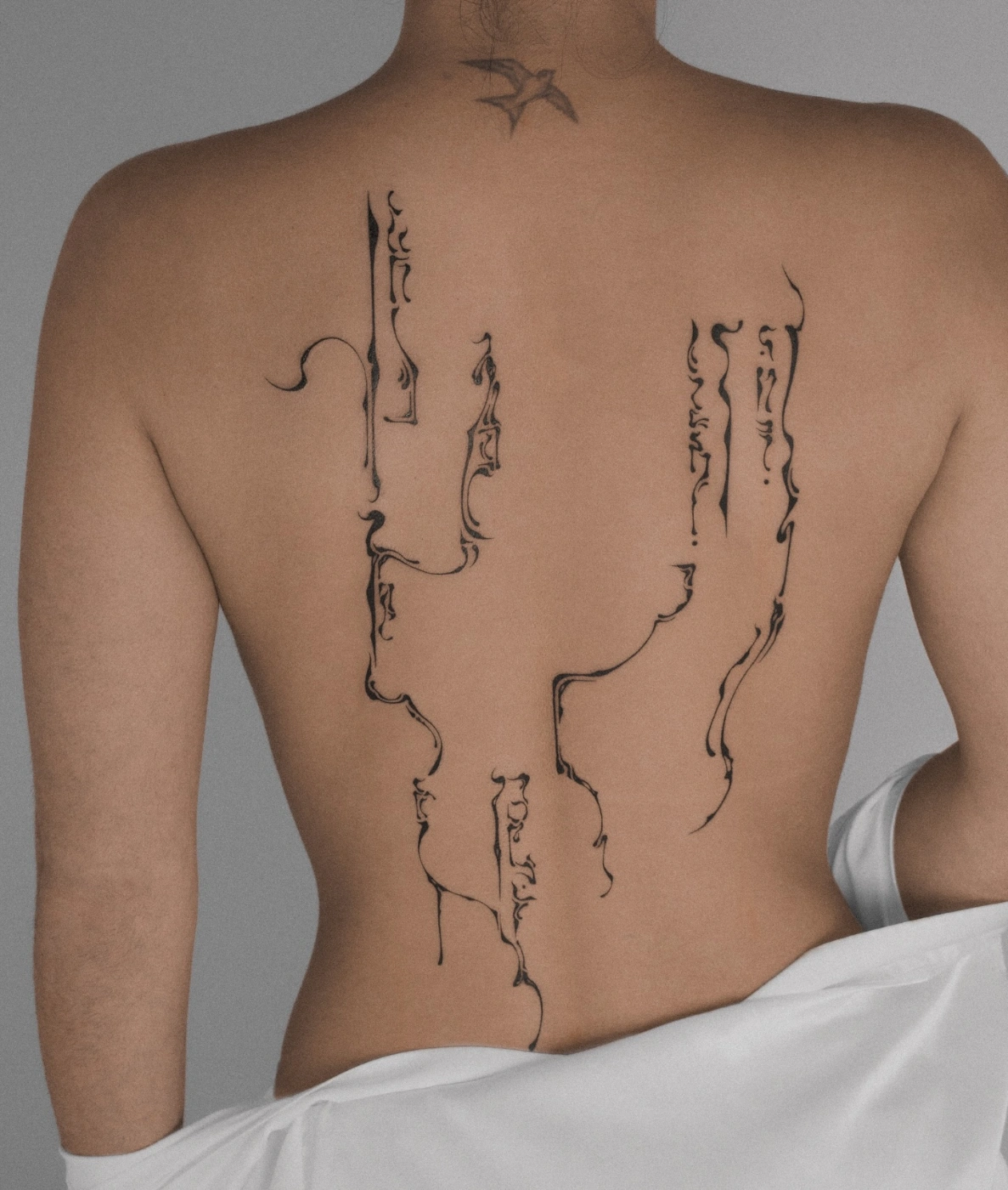 Abstract blackwork tattoo design on a person's back.