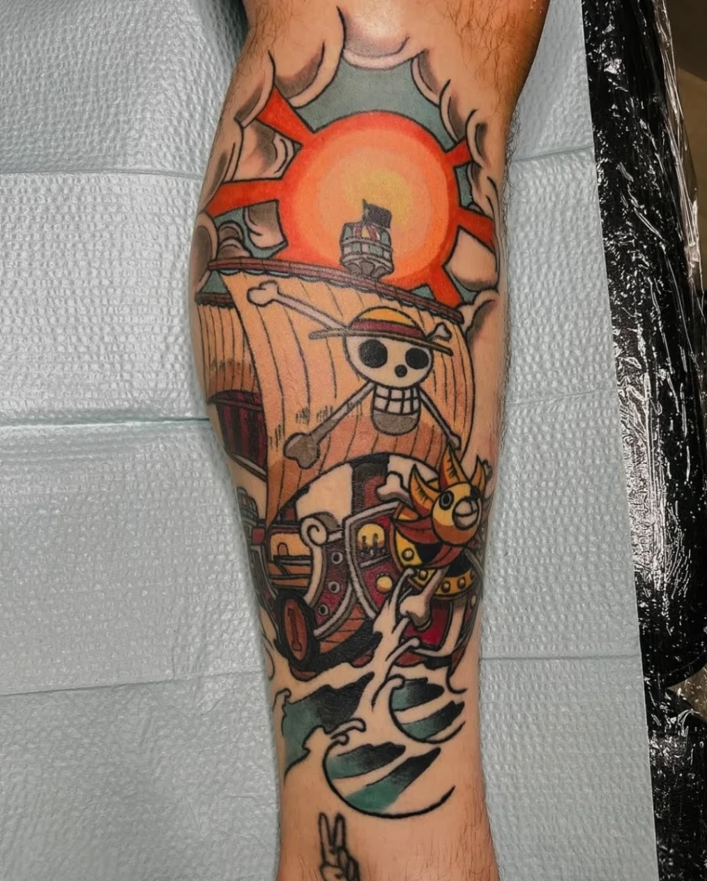 Colorful pirate ship tattoo on forearm.