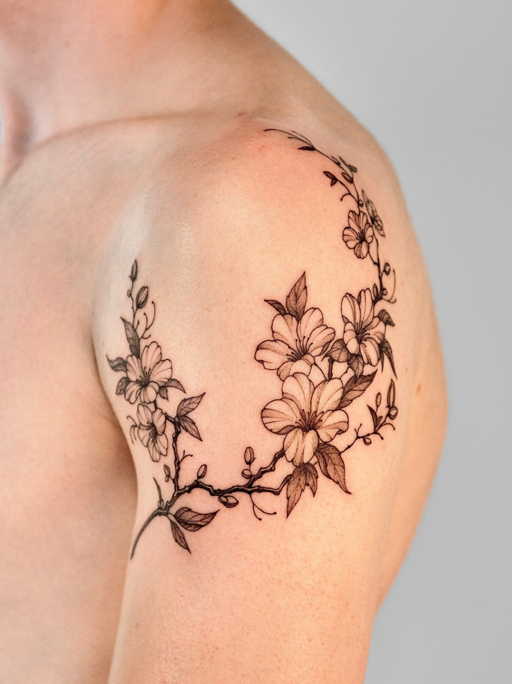 Delicate floral tattoo on shoulder and arm.