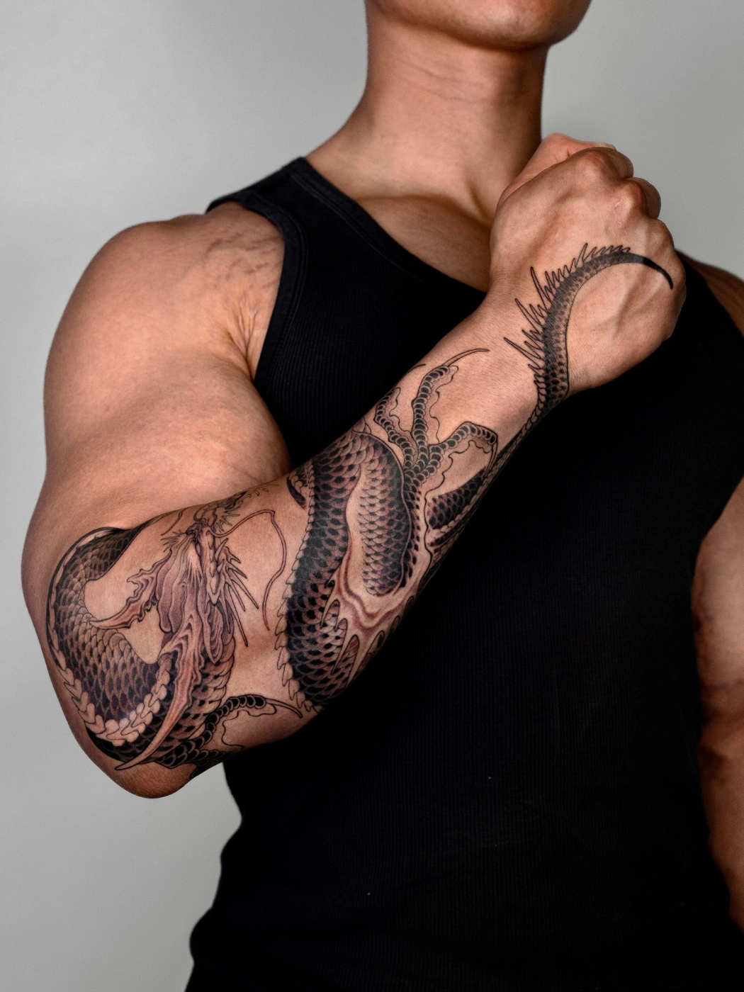 Large blackwork dragon tattoo on forearm.