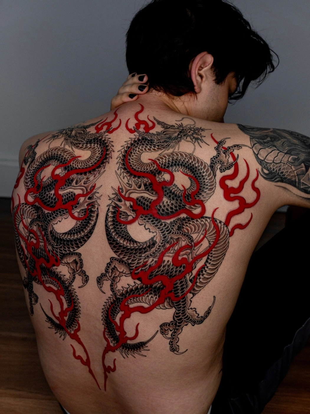 Large back tattoo of dragons and flames.