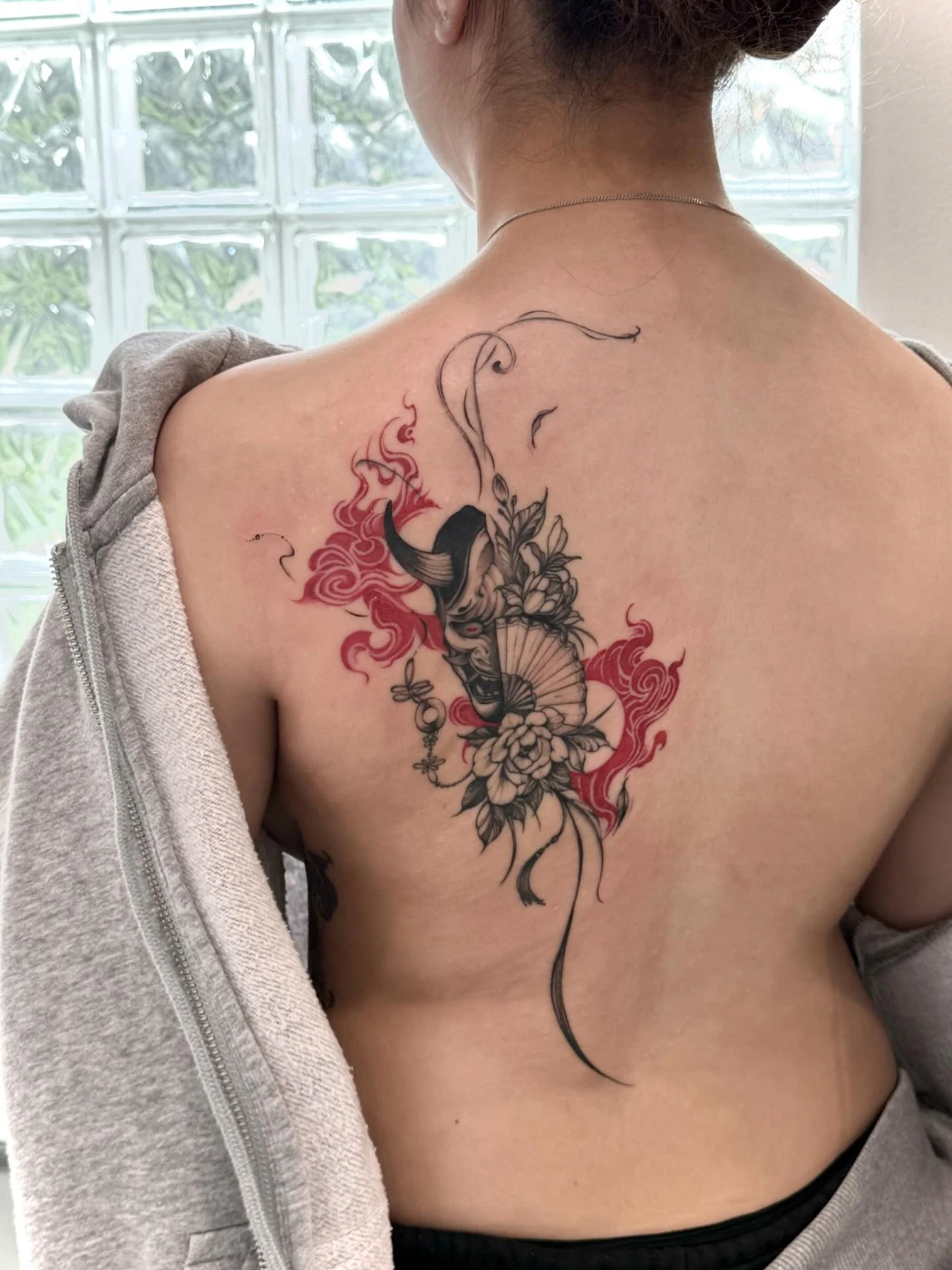 Large colorful koi fish tattoo on a woman's back.