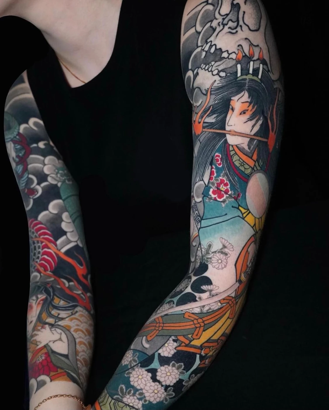 Colorful full-sleeve Japanese tattoo featuring mythical figures.