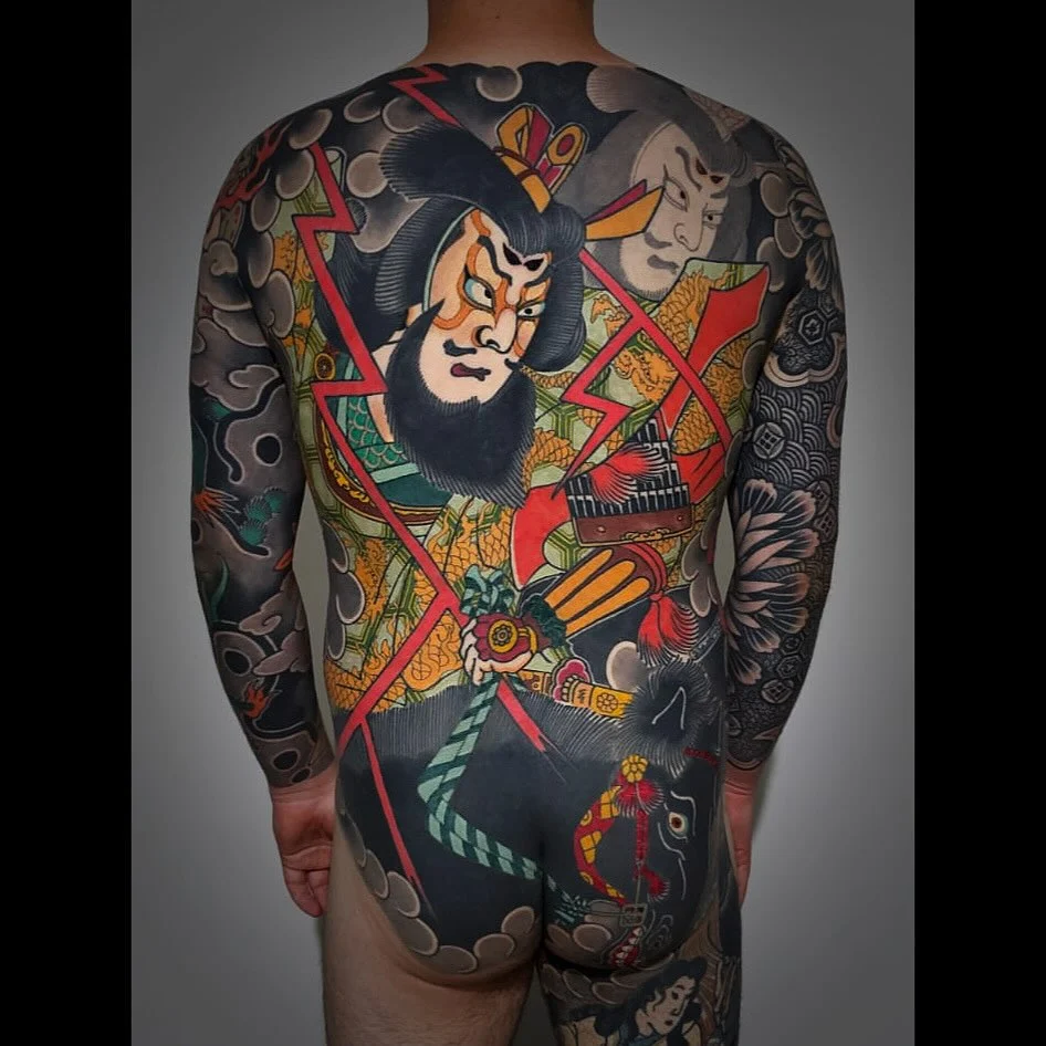 Large Japanese tattoo covering back and sleeves with vibrant colors.