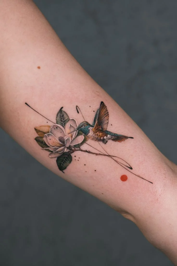 vibrant hummingbird and floral arm tattoo