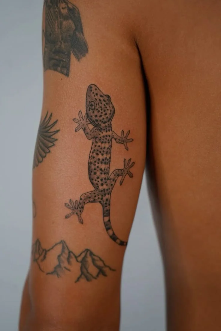 intricate gecko arm tattoo design