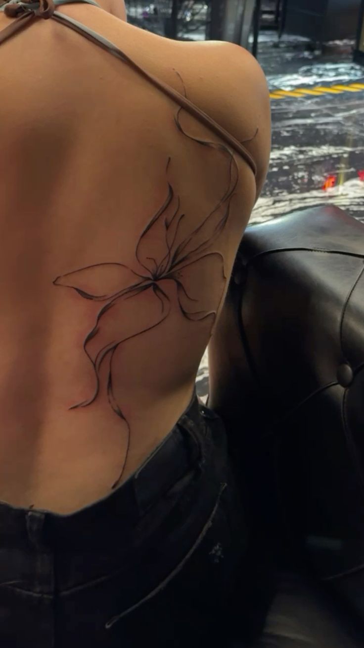 elegant minimalist flower back tattoo