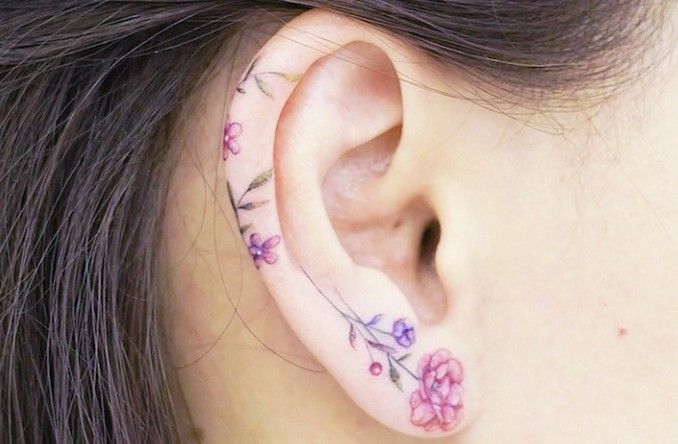 a close up of a person's ear with flowers on it