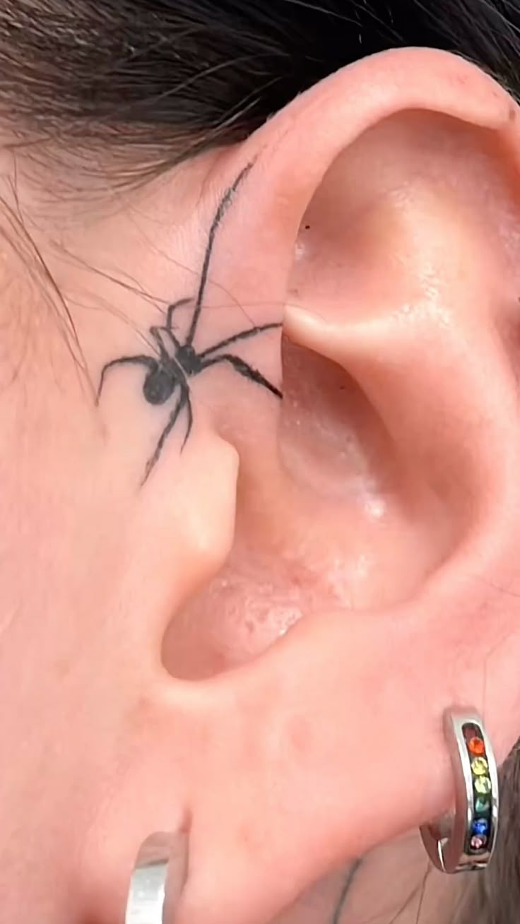 charming spider tattoo behind the ear
