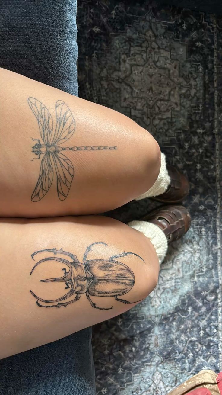 two women with tattoos on their legs sitting next to each other
