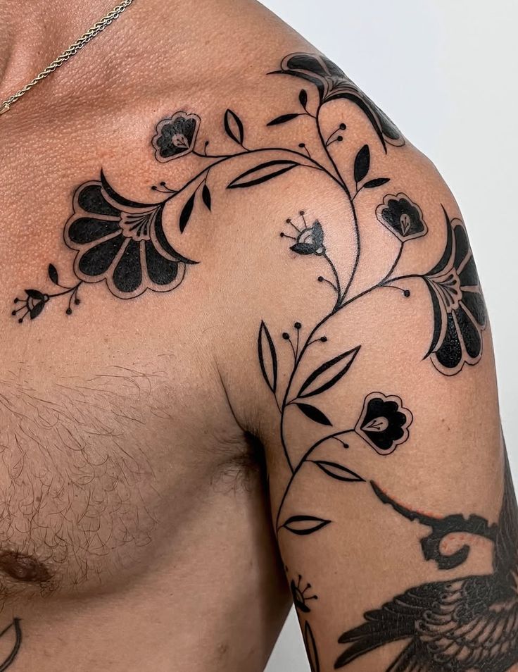 a close up of a man's chest with tattoos on it