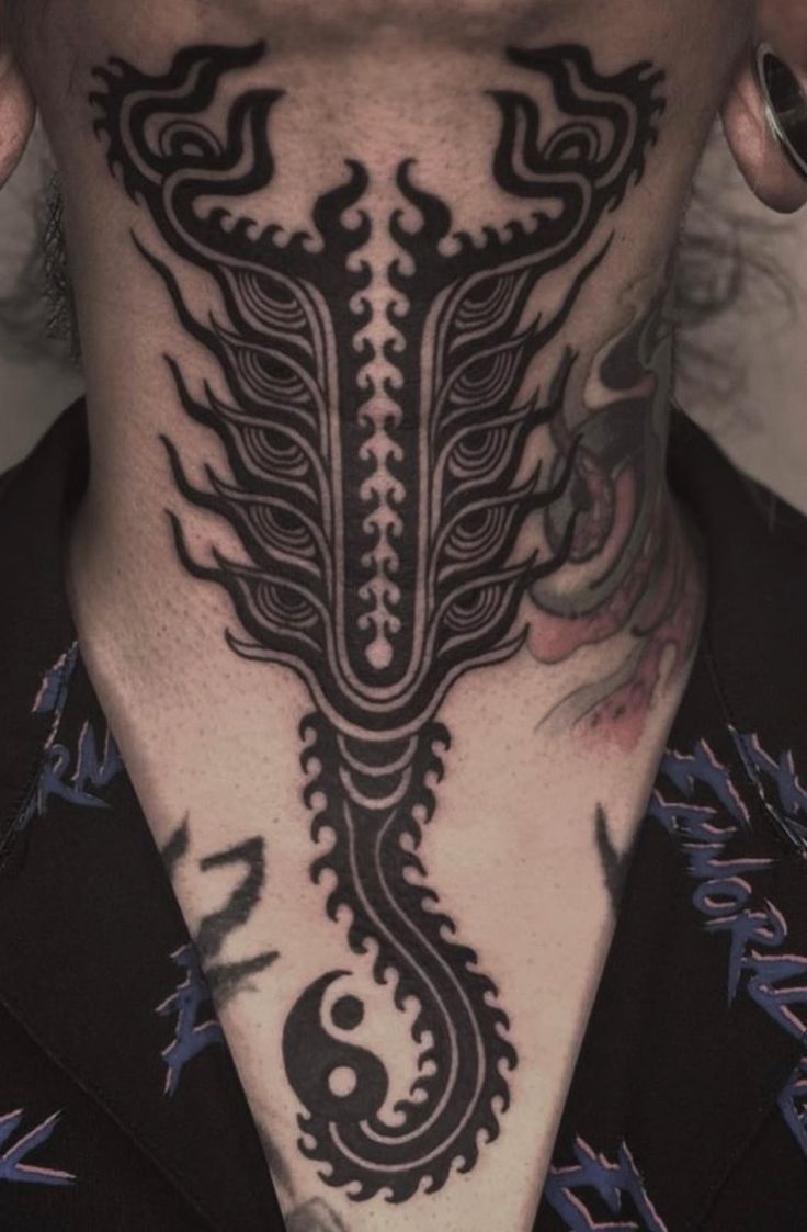 a man with tattoos on his neck and chest