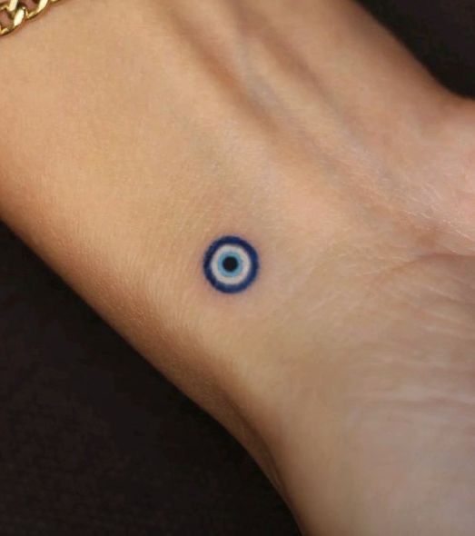 minimalist blue eye finger tattoo