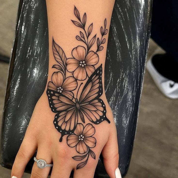 delicate butterfly and floral hand tattoo design