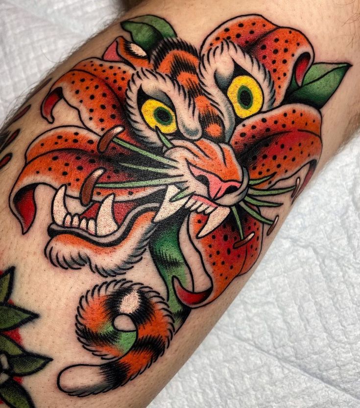 a tiger tattoo on the arm with flowers and leaves around it's neck,