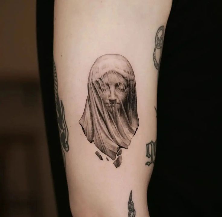 Veiled Surrealism: A Unique Arm Tattoo