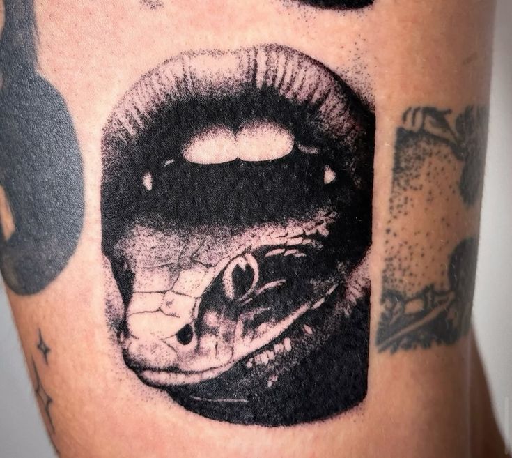 a close up of a person's leg with a snake and lips on it