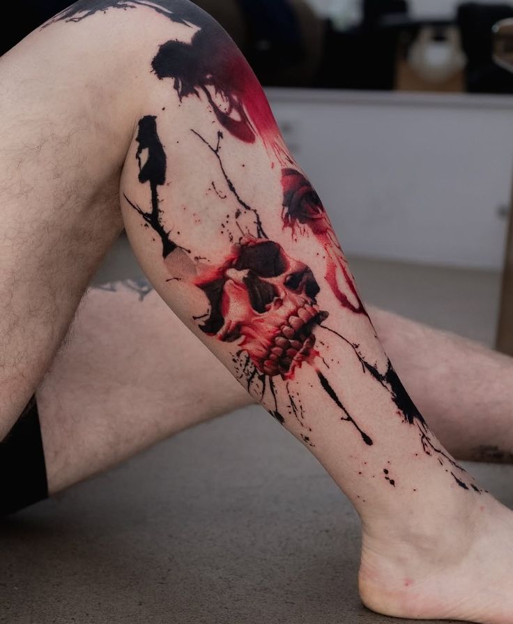 a man's leg covered in blood and ink with a skull tattoo on it