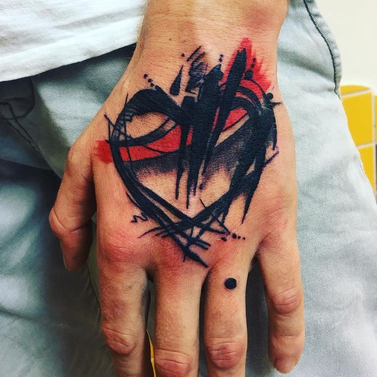 a man's hand with a black and red heart tattoo on his left palm