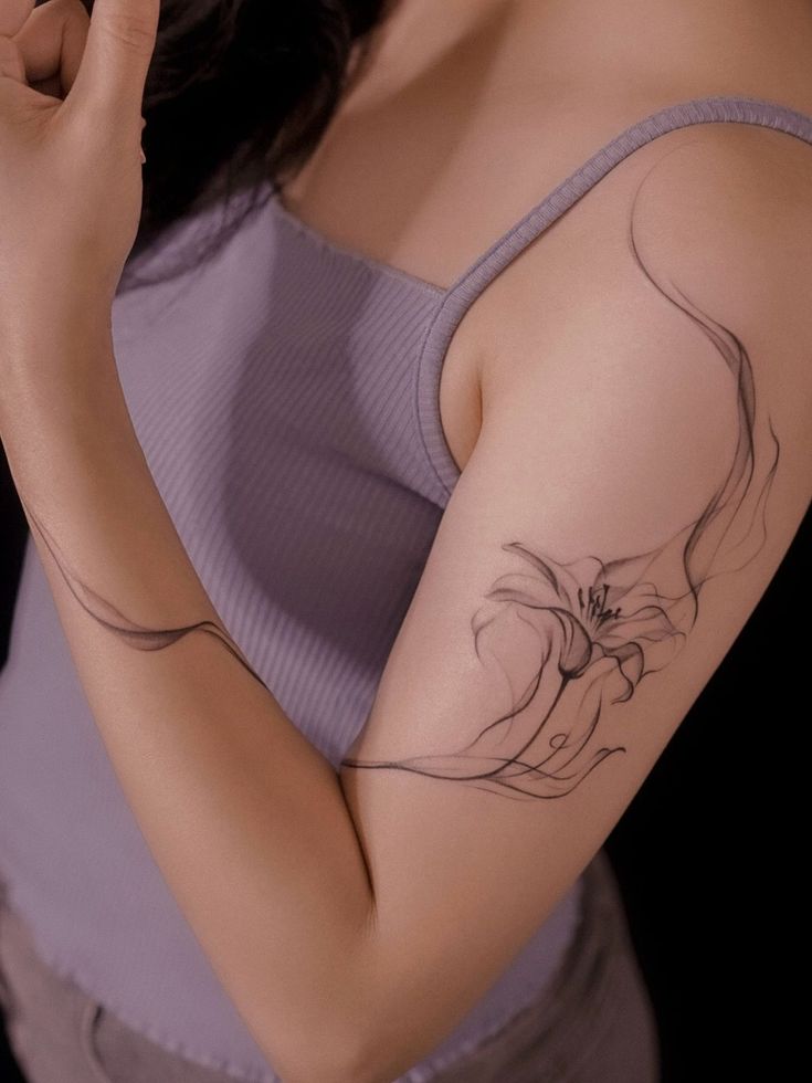 a woman with a flower tattoo on her arm holding a cell phone to her ear