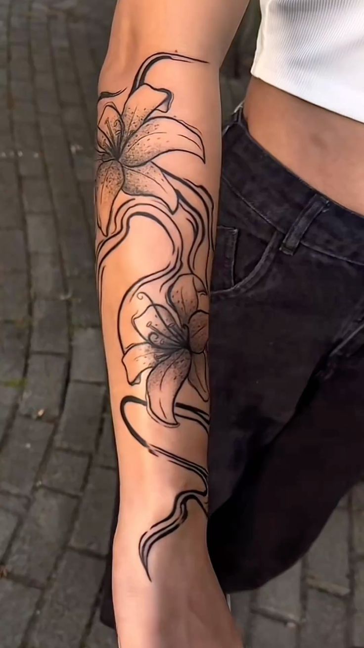 a woman's arm with a flower tattoo on the left side of her arm
