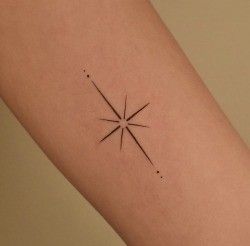 a person's arm with a small star tattoo on the left side of their arm